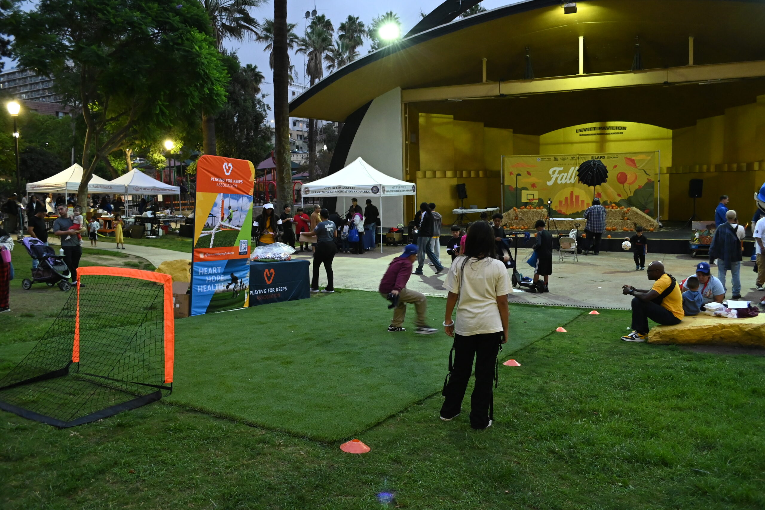 Outdoor event at MacArthur Park with stage, tents, and people.