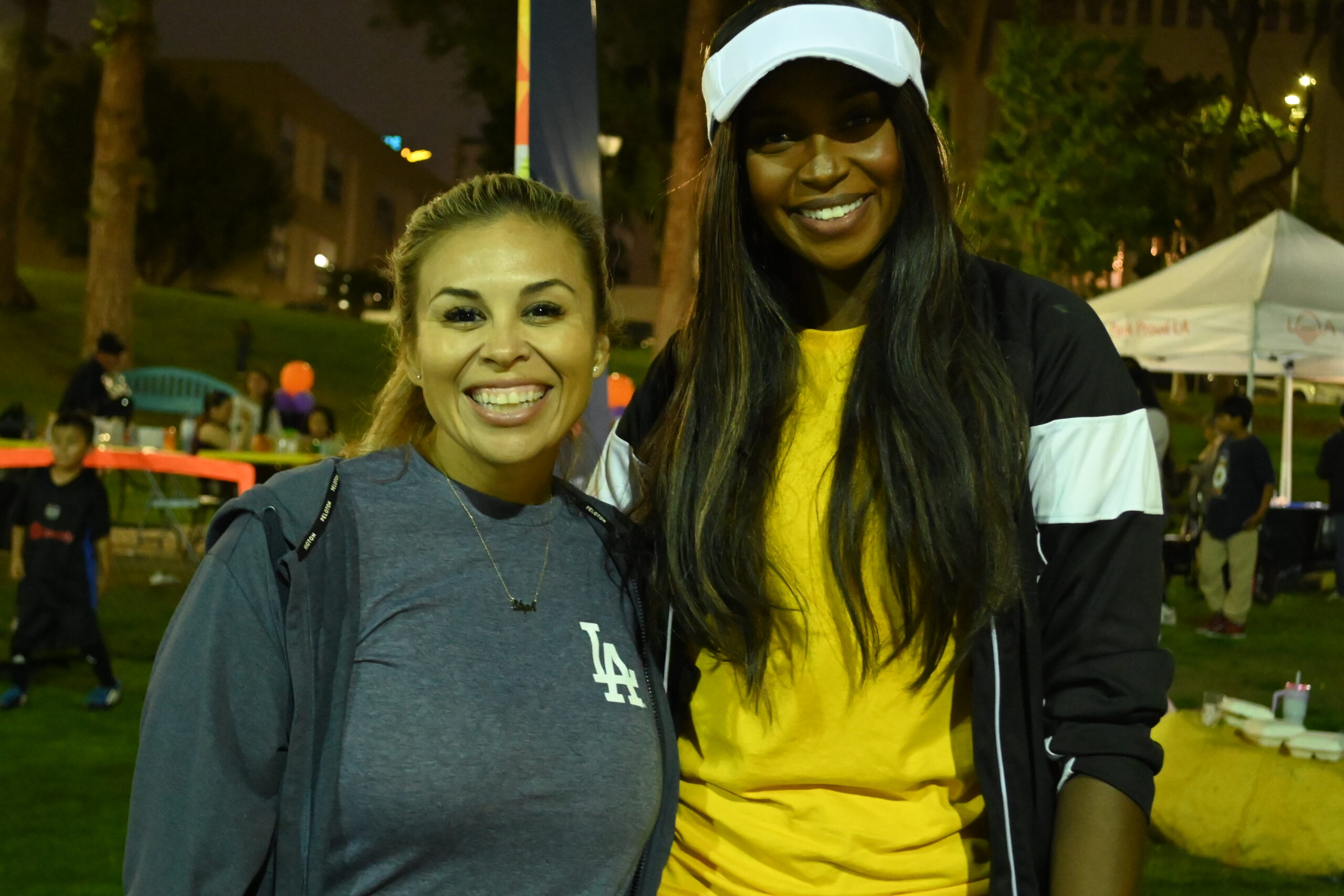 Installer at MacArthur Park event Two smiling women at MacArthur Park during an outdoor event.