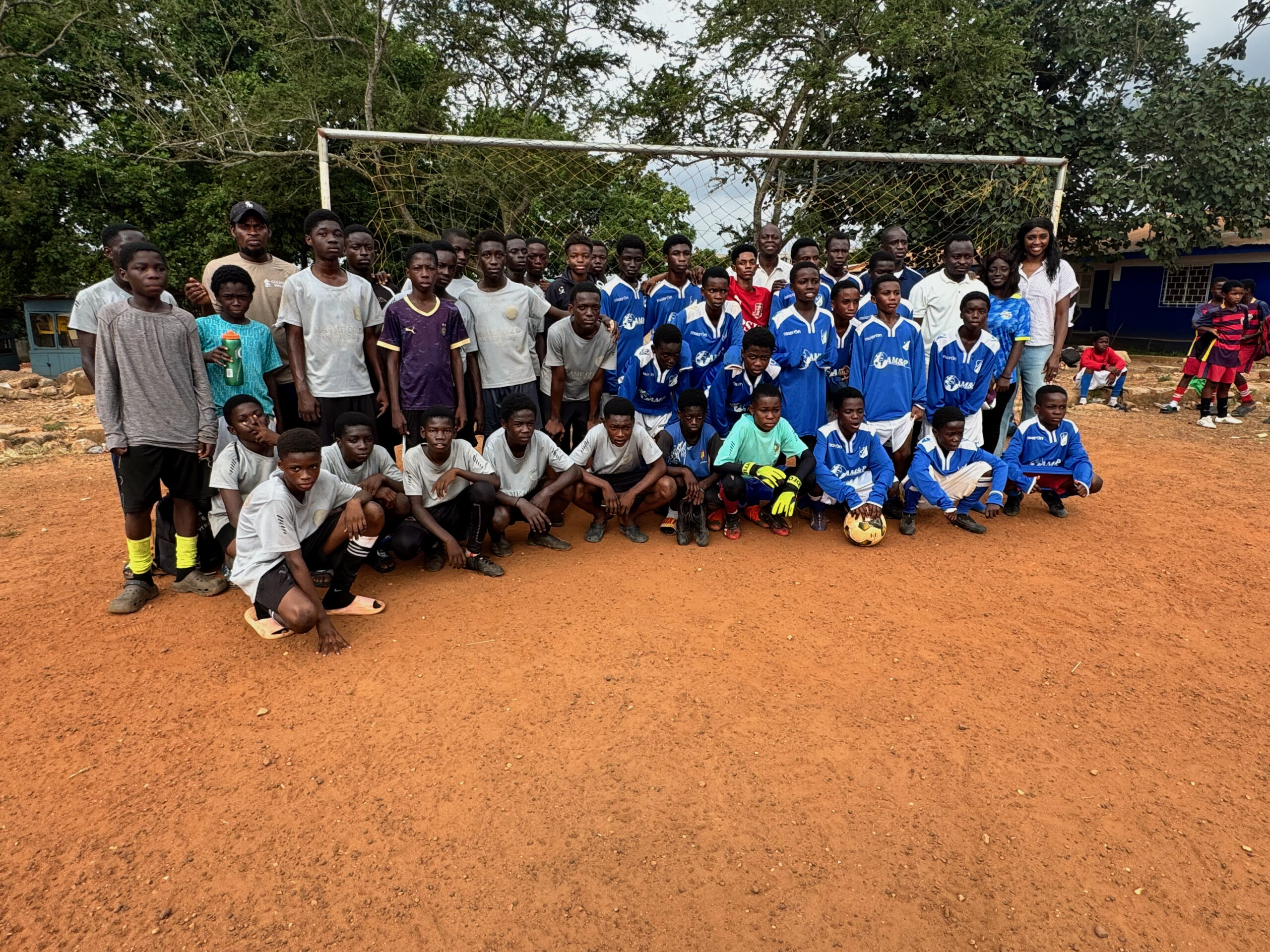 The youth football academy teams gathered on the dirt pitch in Kumasi, Ghana.