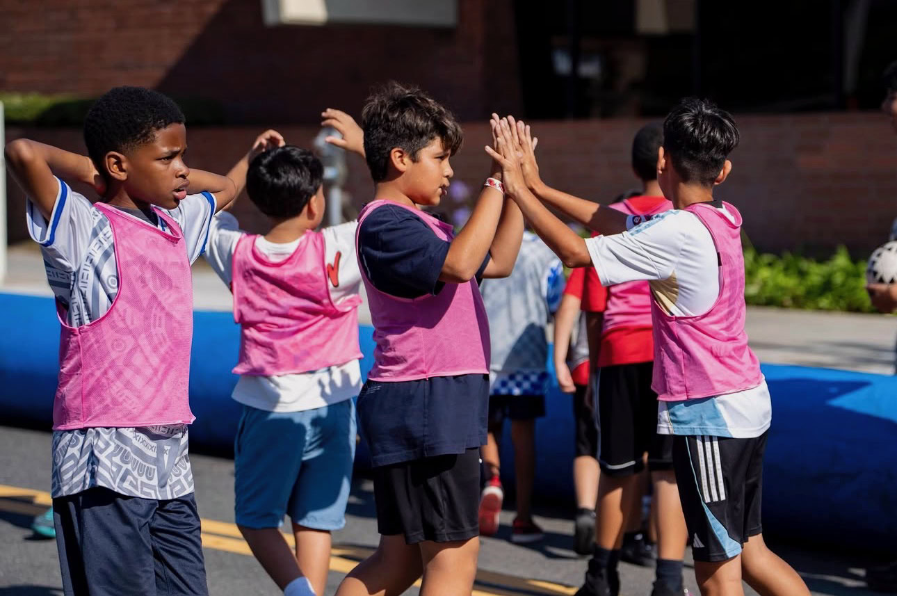 Children playing high-five game at FIFA Kids Zone in Iran vs New Zealand event.