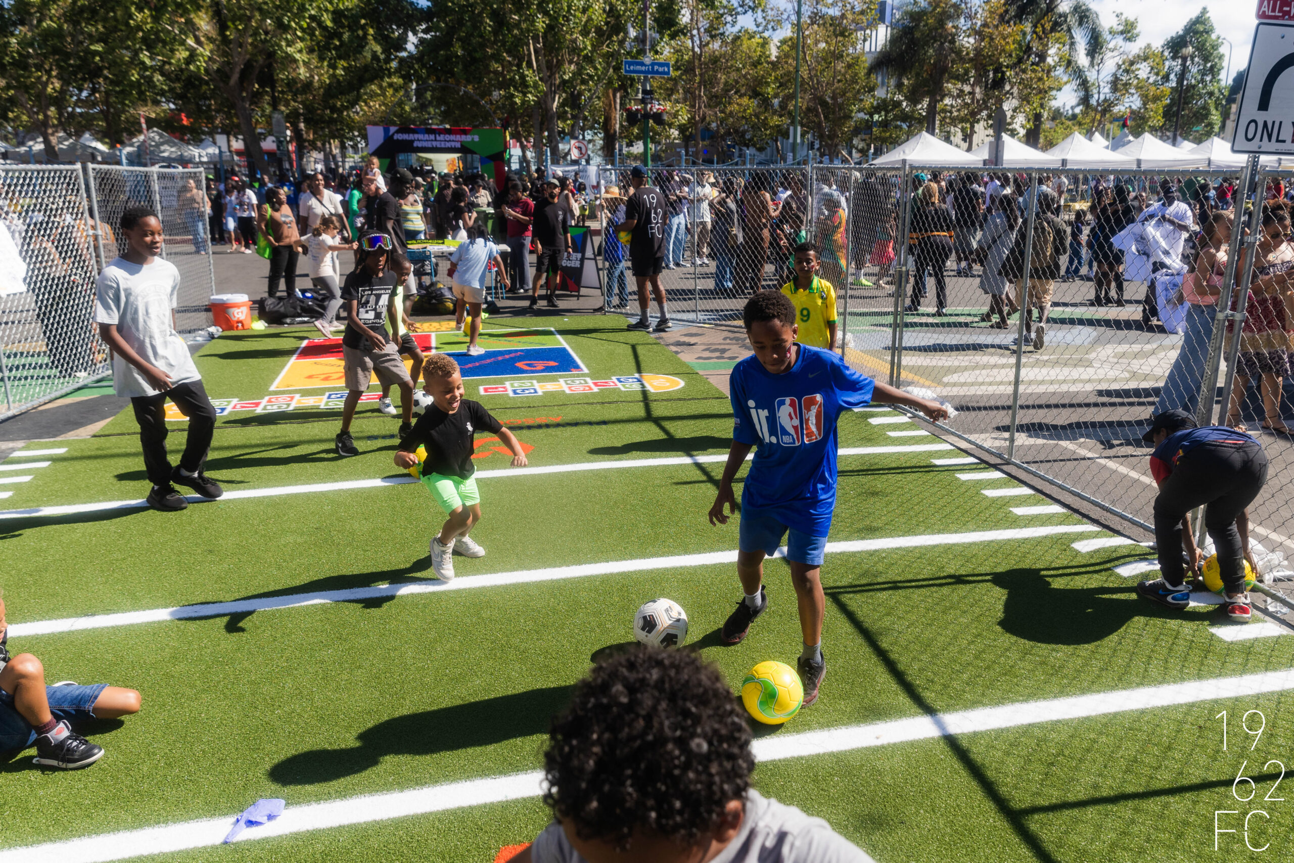 Children Playing Soccer on Artificial Turf Kids playing soccer on a small artificial turf field at an outdoor event.
