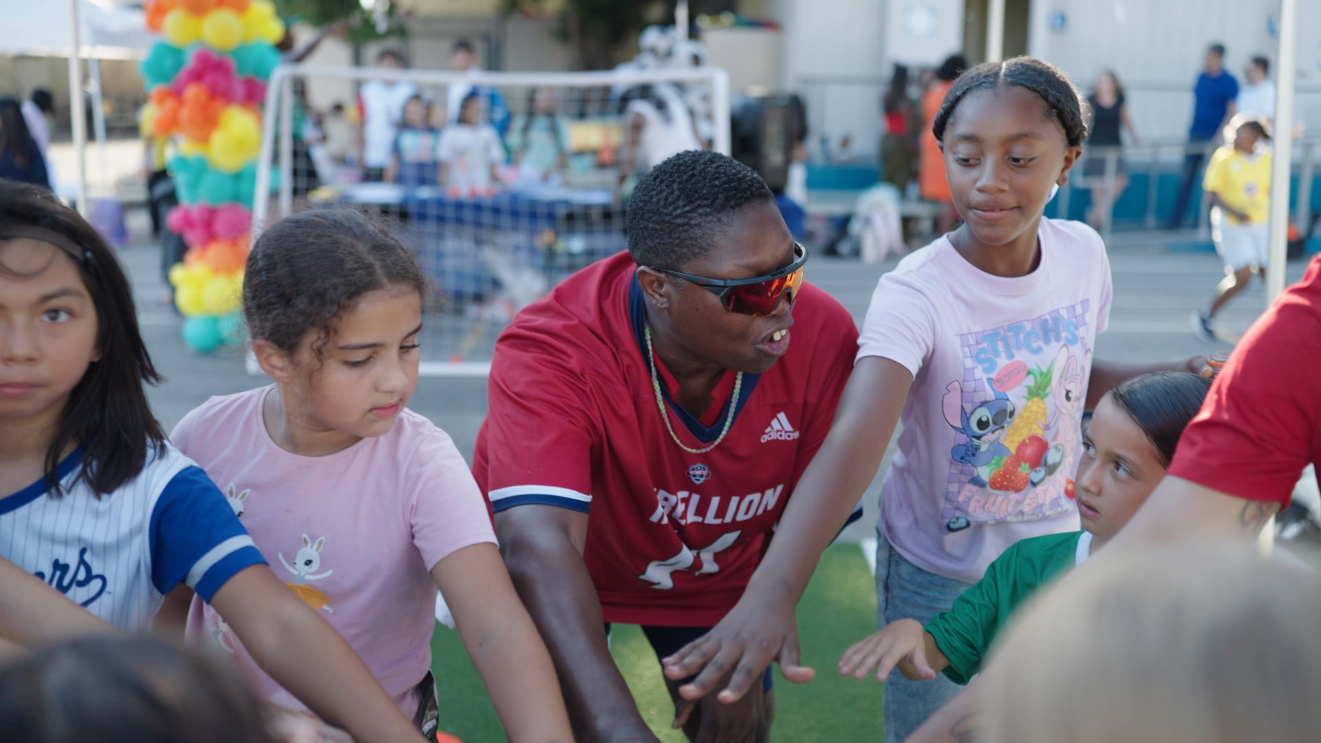 Children and adult at outdoor event Group of children and adult engaging at outdoor community event.